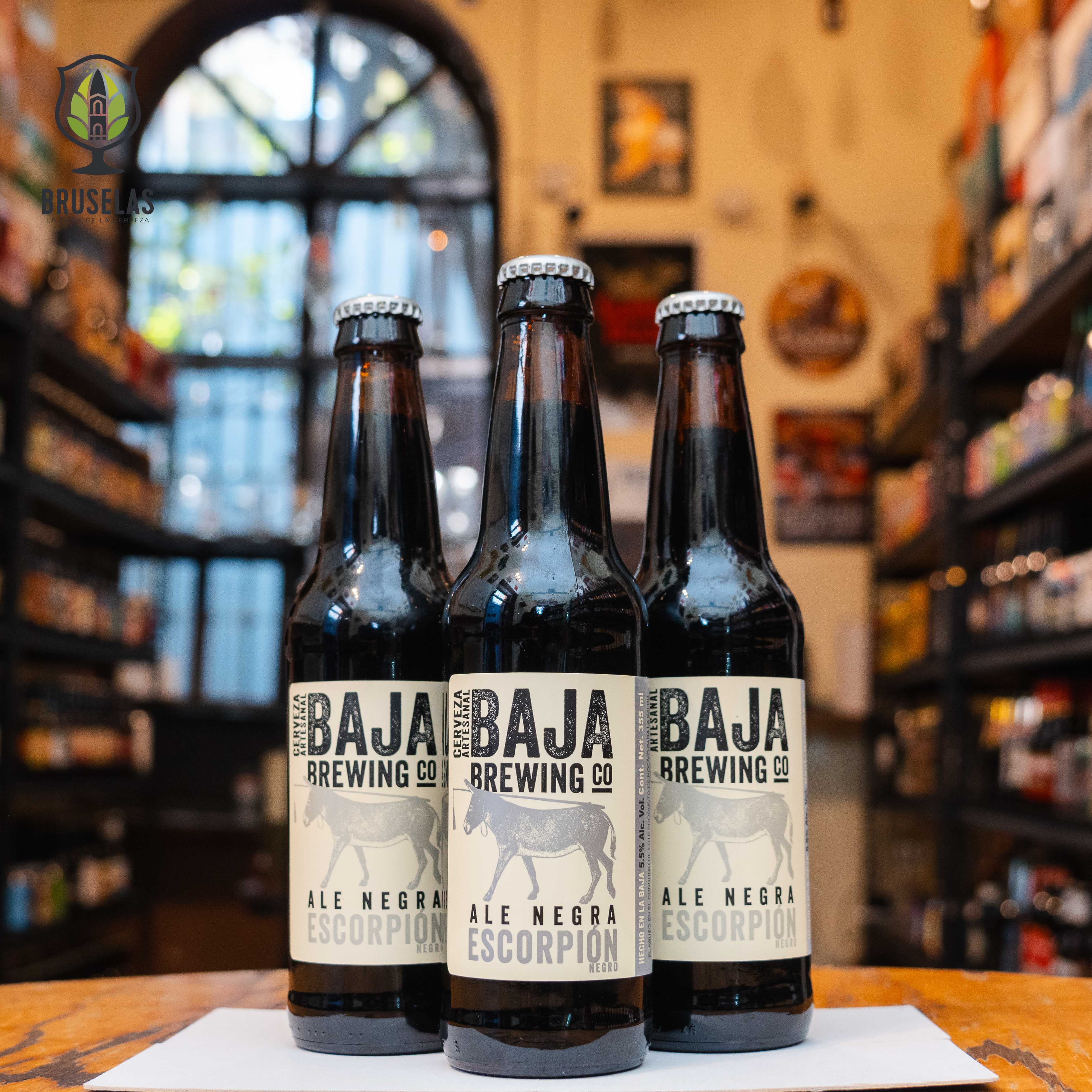 Botella de Baja Escorpión Negro, una Schwarzbier de Baja Brewing Co. La etiqueta presenta un diseño oscuro y elegante. Con un ABV de 5.5%, esta cerveza negra ofrece aromas tostados de café y chocolate. Su sabor es suave, con un toque de caramelo y un final limpio. Ideal para maridar con hamburguesas a la parrilla, costillas asadas y postres de chocolate. Una cerveza oscura de cuerpo ligero, perfecta para quienes disfrutan de sabores equilibrados.