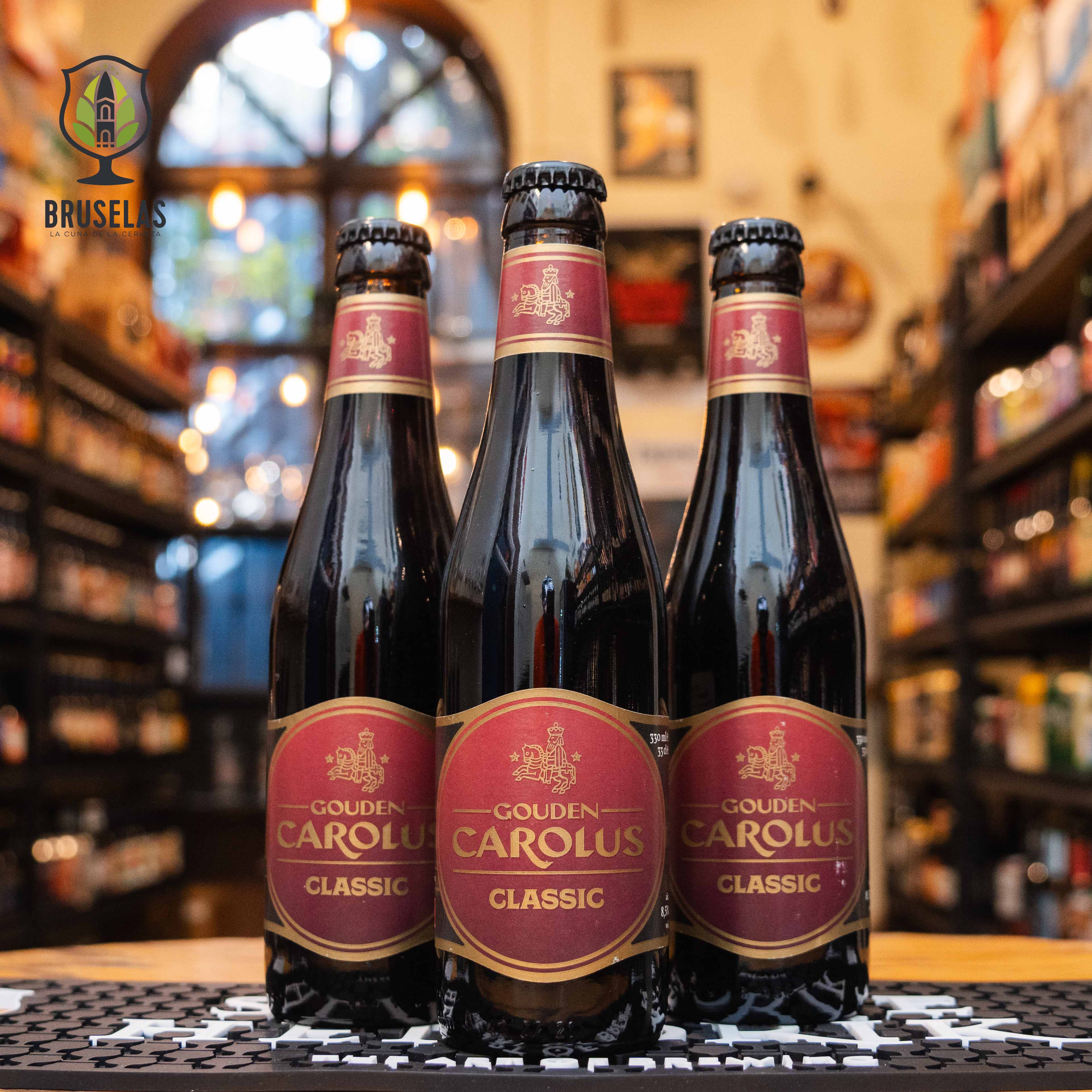 Botella de Gouden Carolus Classic, una Belgian Dark Strong Ale de Brouwerij Het Anker en Mechelen, Bélgica. La etiqueta presenta un diseño elegante con detalles dorados y rojos, y el nombre en letras doradas. Con un ABV de 8.5%, esta cerveza ofrece un sabor complejo que combina notas de caramelo, frutas secas y especias, equilibrando dulzor y amargor. Ideal para maridar con guisos, carnes de caza y quesos maduros. El diseño de la botella refleja la rica tradición cervecera belga.