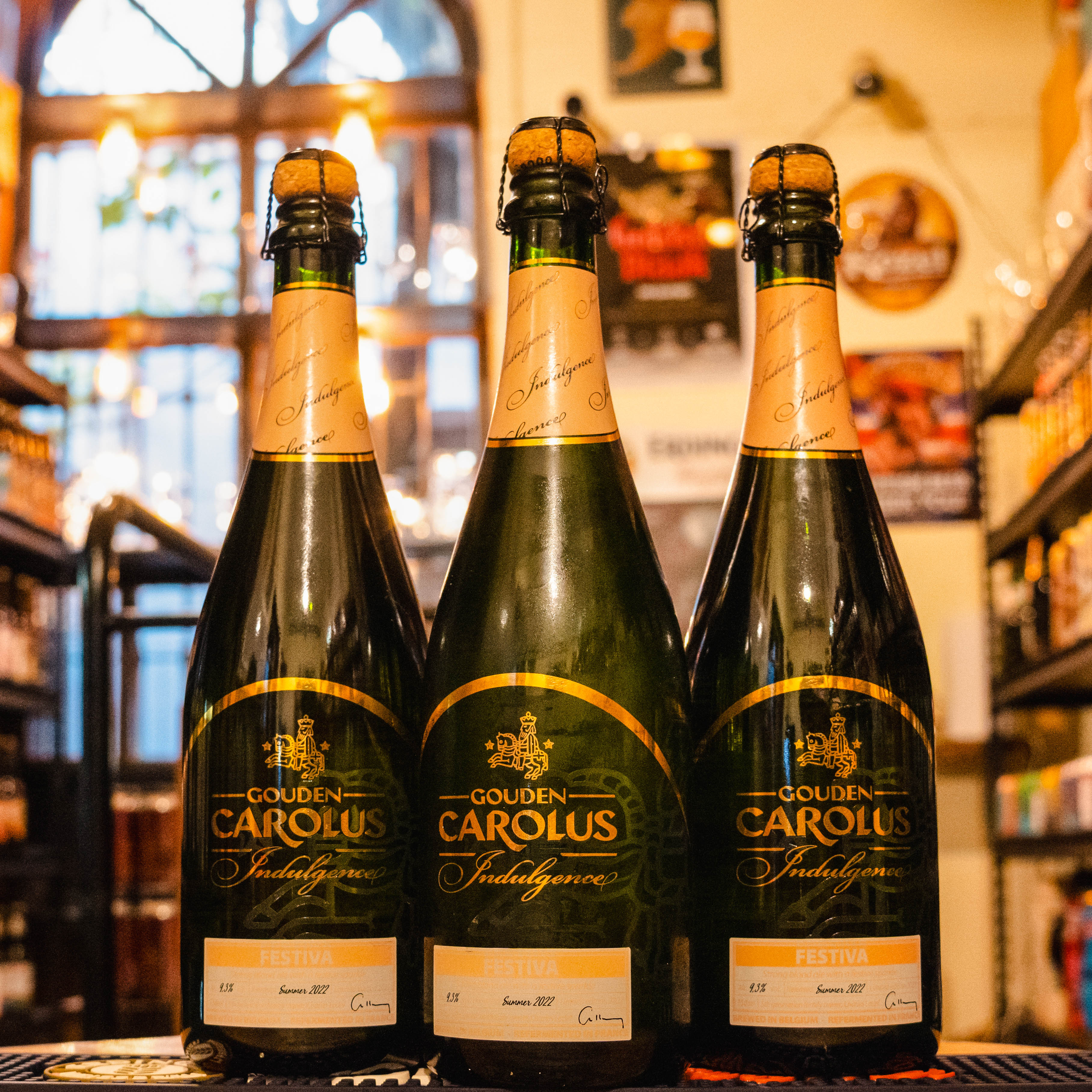 Botella de Gouden Carolus Indulgence 2022, una edición limitada de Belgian Strong Golden Ale de Brouwerij Het Anker. Con un ABV de 9.8%, ofrece aromas de frutas verdes, uvas y ligeras notas amaderadas por su maduración en barricas de vino sauvignon. Su sabor incluye cítricos, pera y manzana verde, con una suave acidez y un final seco. Ideal para maridar con pescados grasos, quesos suaves y ensaladas frescas.