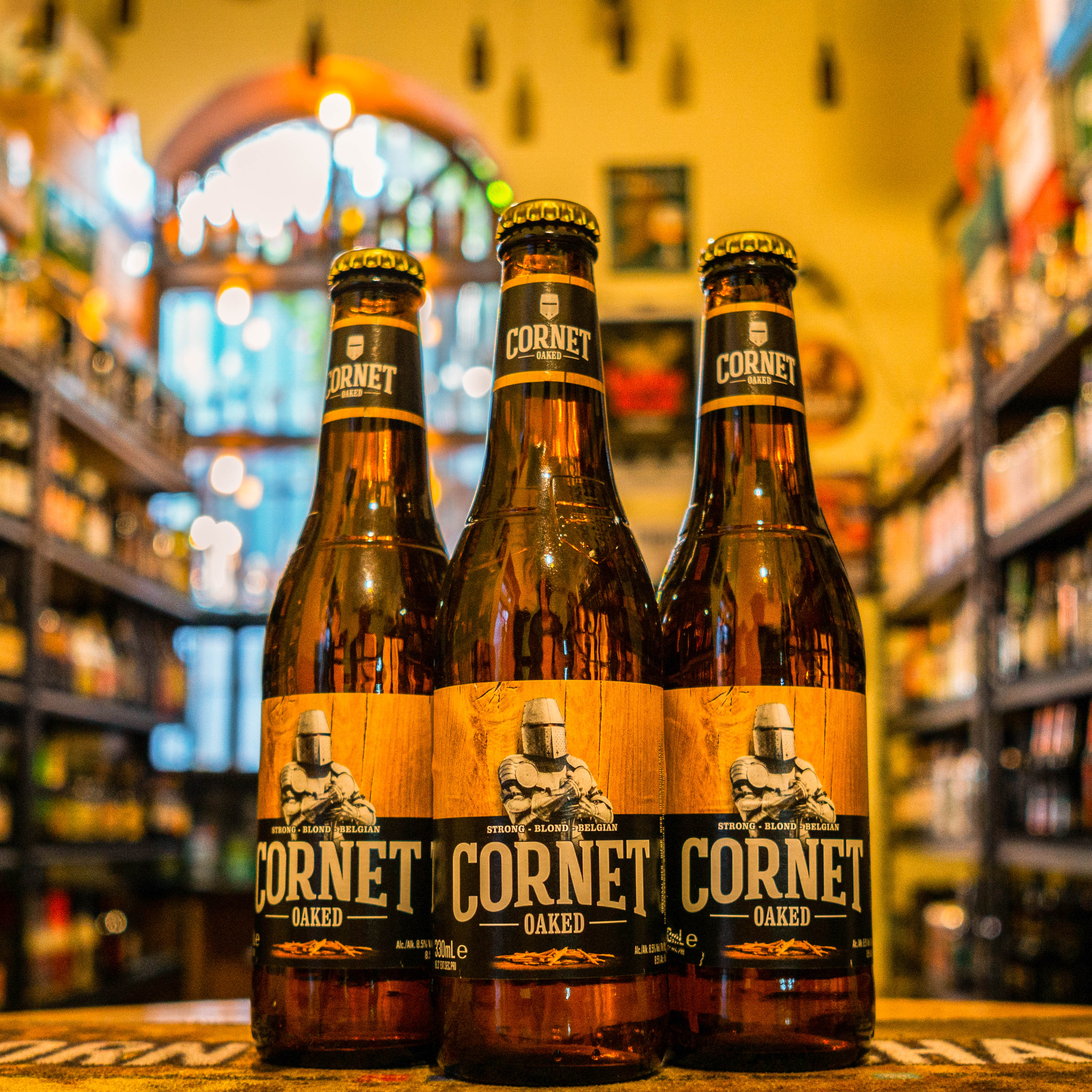 Botella de Cornet Oaked, una Belgian Strong Ale elaborada por Brouwerij De Hoorn. Con un ABV de 8.5%, esta cerveza destaca por su distintivo sabor a roble, logrado mediante la adición de virutas de roble durante su maduración. Presenta aromas de vainilla, roble y malta tostada, mientras que su sabor combina notas de madera y vainilla con un final ligeramente amargo. Ideal para maridar con carnes ahumadas, quesos maduros y chocolate amargo.