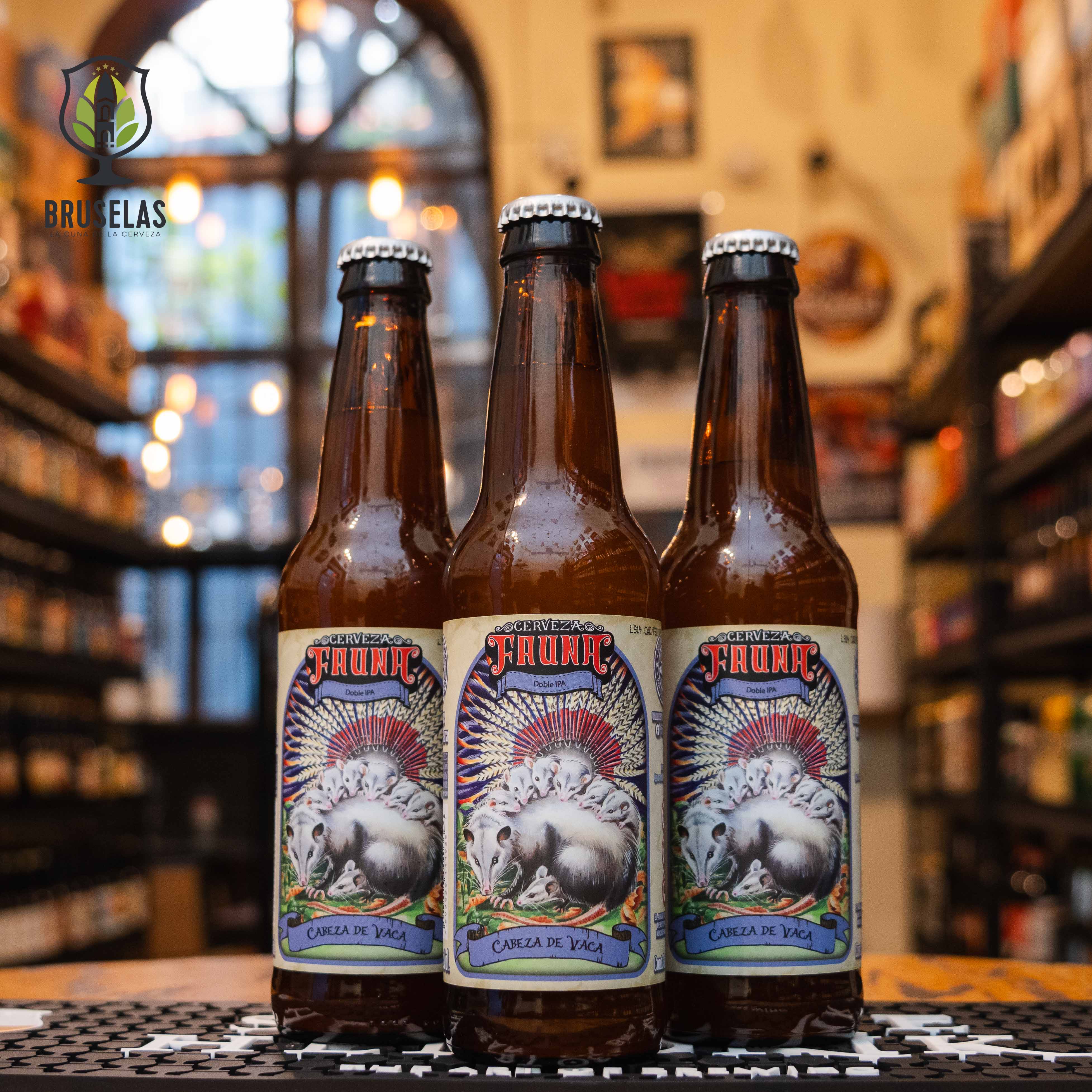 Botella de Fauna Cabeza de Vaca, una Double IPA de Cervecería Fauna en Mexicali, Baja California. Con un ABV del 9% y 60 IBU, presenta un perfil robusto y lupulado, con aromas de toronja, pino y frutas tropicales. Su amargor pronunciado está equilibrado por un cuerpo maltoso que aporta una ligera dulzura. Ideal para maridar con carnes asadas y quesos maduros. Presentación en botella de 355 ml.