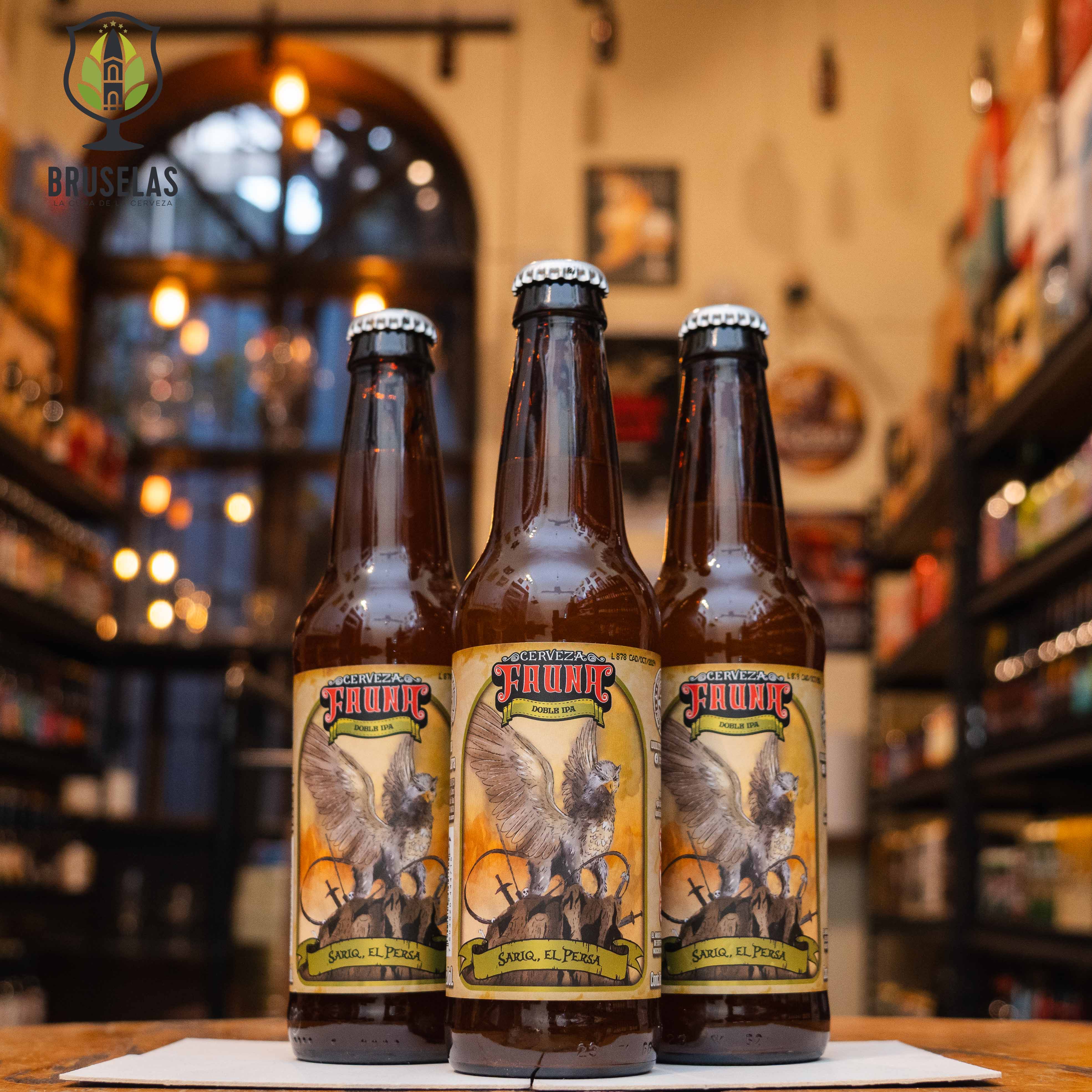 Botella de Fauna Sariq El Persa, una Doble IPA de Cervecería Fauna, elaborada en Mexicali, Baja California. La etiqueta presenta un diseño exótico con colores cálidos y detalles orientales. Con un ABV de 8.7% y un IBU de 40, ofrece aromas de mango, piña, cáscara de naranja y toronja. Su sabor es frutal y tropical, con notas de durazno, guayaba y lúpulo. Ideal para maridar con platos especiados y carnes a la parrilla.