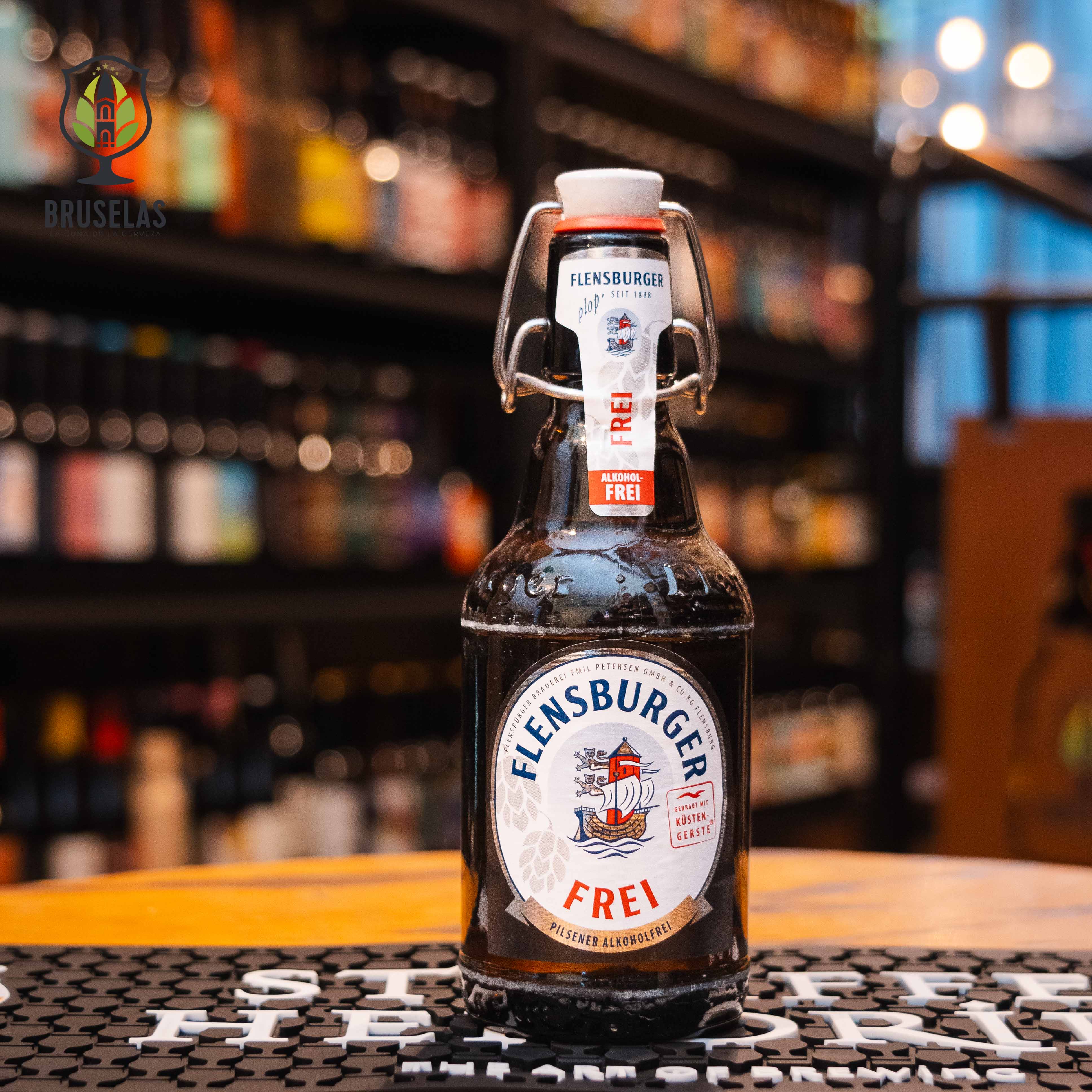 Botella de Flensburger Frei, una lager sin alcohol de la cervecería Flensburger Brauerei, elaborada en Alemania. La etiqueta presenta un diseño clásico con tonos azules y el logotipo característico de la marca. Con un ABV de 0.0%, ofrece un aroma de malta ligera y notas herbales, con un sabor refrescante y un final limpio y ligeramente amargo. Ideal para disfrutar en cualquier momento del día, gracias a su perfil ligero.