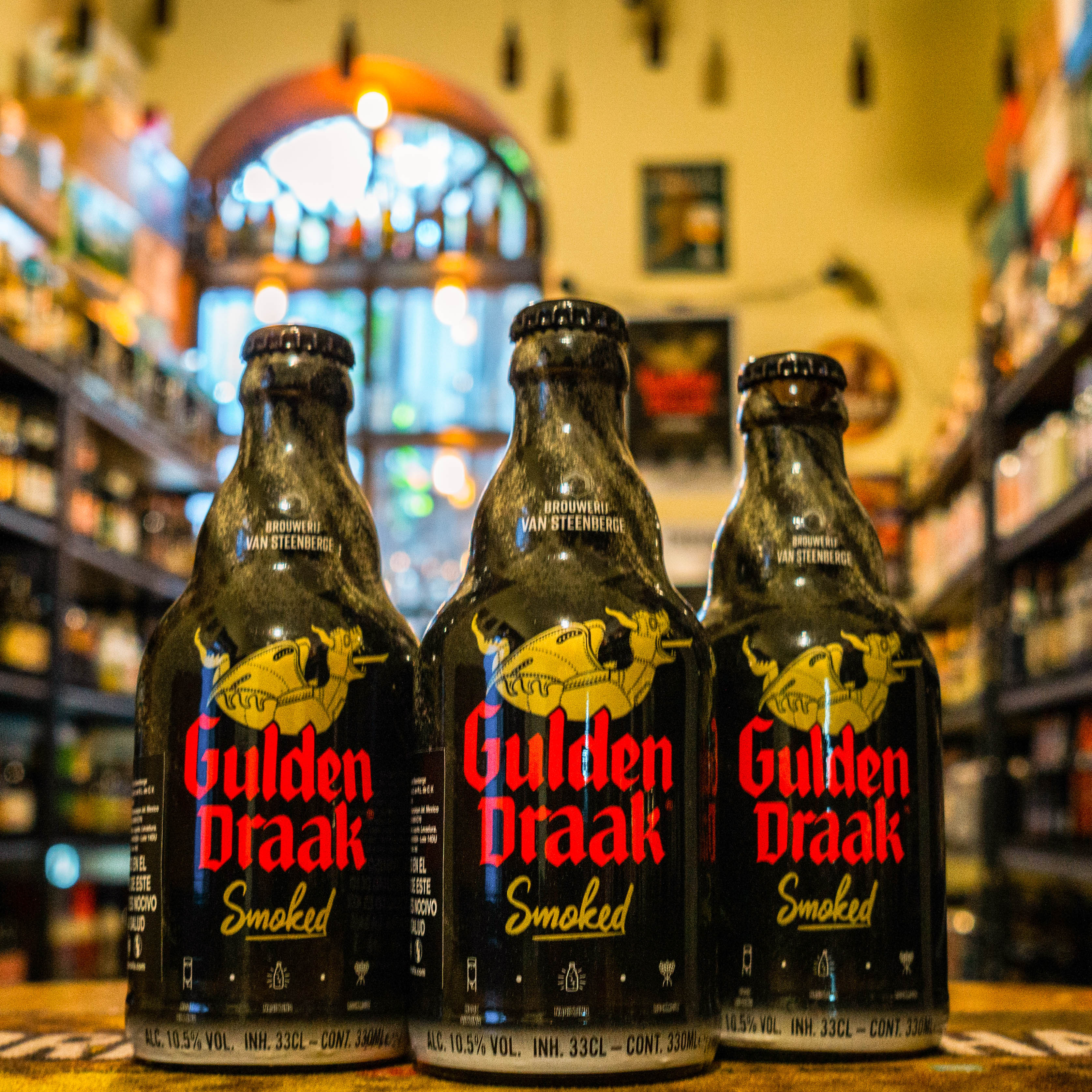 La Gulden Draak Smoked es una cerveza belga oscura estilo Smoked Quadrupel, elaborada por Brouwerij Van Steenberge. Con un ABV del 10.5%, se distingue por su malta secada al fuego, que le aporta un sabor ahumado profundo. Combina notas dulces de caramelo, chocolate y frutas oscuras, equilibradas con un toque amargo al final. Es ideal para maridar con carnes ahumadas, quesos fuertes y postres de chocolate oscuro.