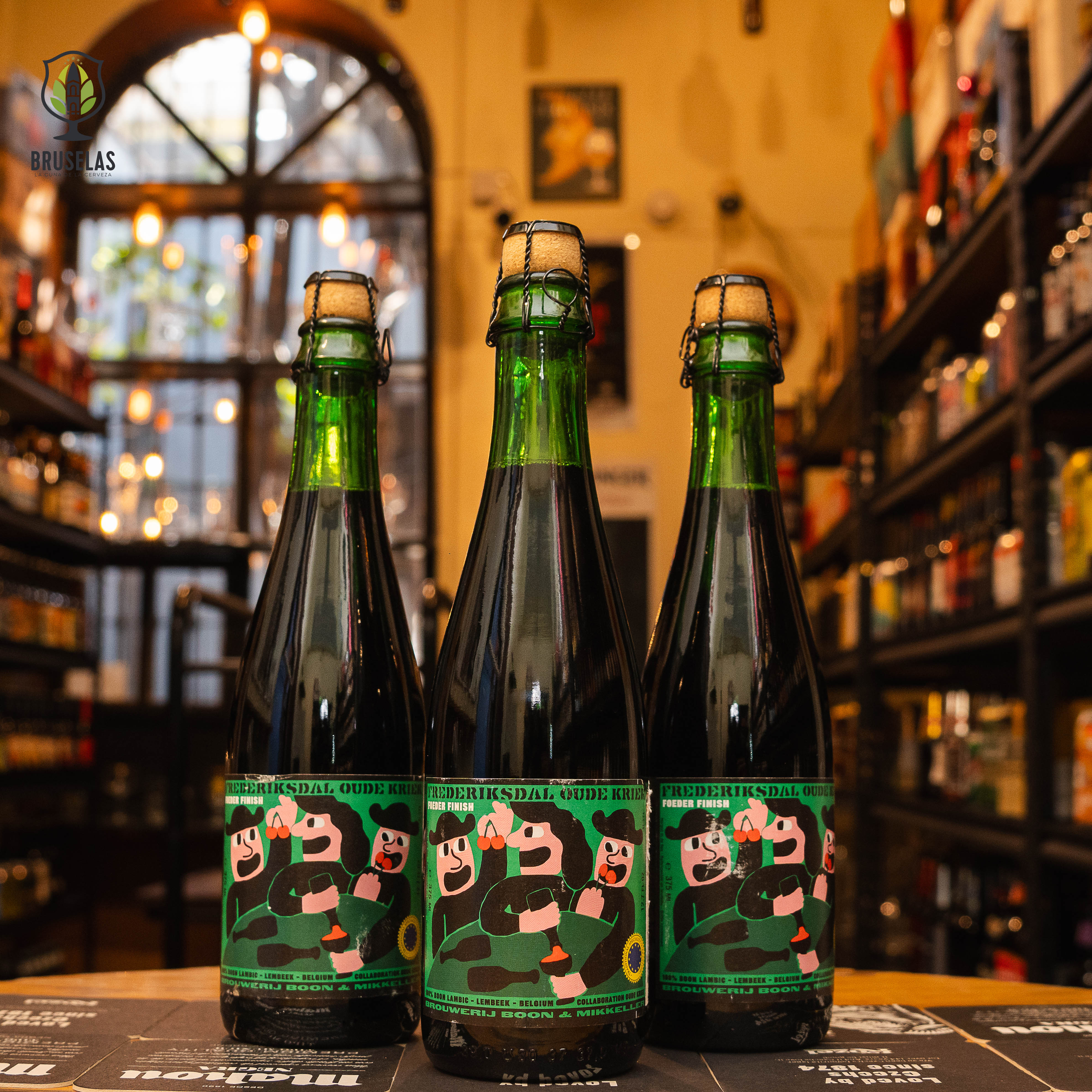 Botella de Mikkeller Frederiksdal Oude Kriek, una cerveza estilo Kriek fruto de la colaboración entre Mikkeller y Frederiksdal. Con un ABV de 6-7%, presenta un color rojo profundo y aromas de cereza ácida y notas de roble. Su sabor es afrutado y ácido, con un toque de dulzura. Ideal para maridar con postres de chocolate y quesos suaves. Refleja complejidad y frescura en una cerveza frutal.