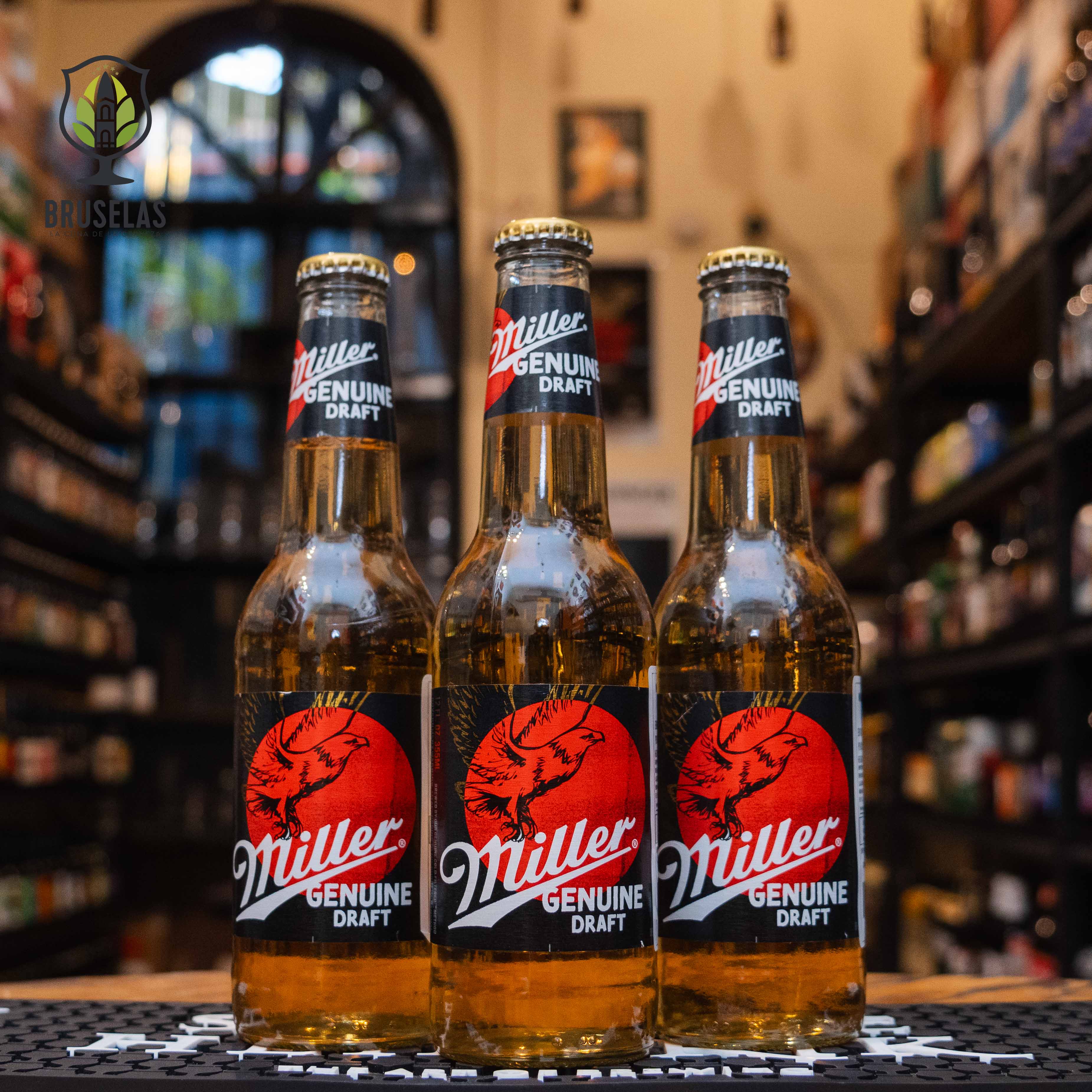 Botella de Miller Genuine Draft, una lager americana de 4.7% ABV de Miller Brewing Company. La etiqueta negra y roja destaca su estilo clásico. Esta cerveza ofrece un sabor ligero y refrescante, con un toque suave de malta y un final equilibrado. Ideal para maridar con pizzas, hamburguesas y botanas, es perfecta para quienes buscan una opción fácil de beber y de calidad.