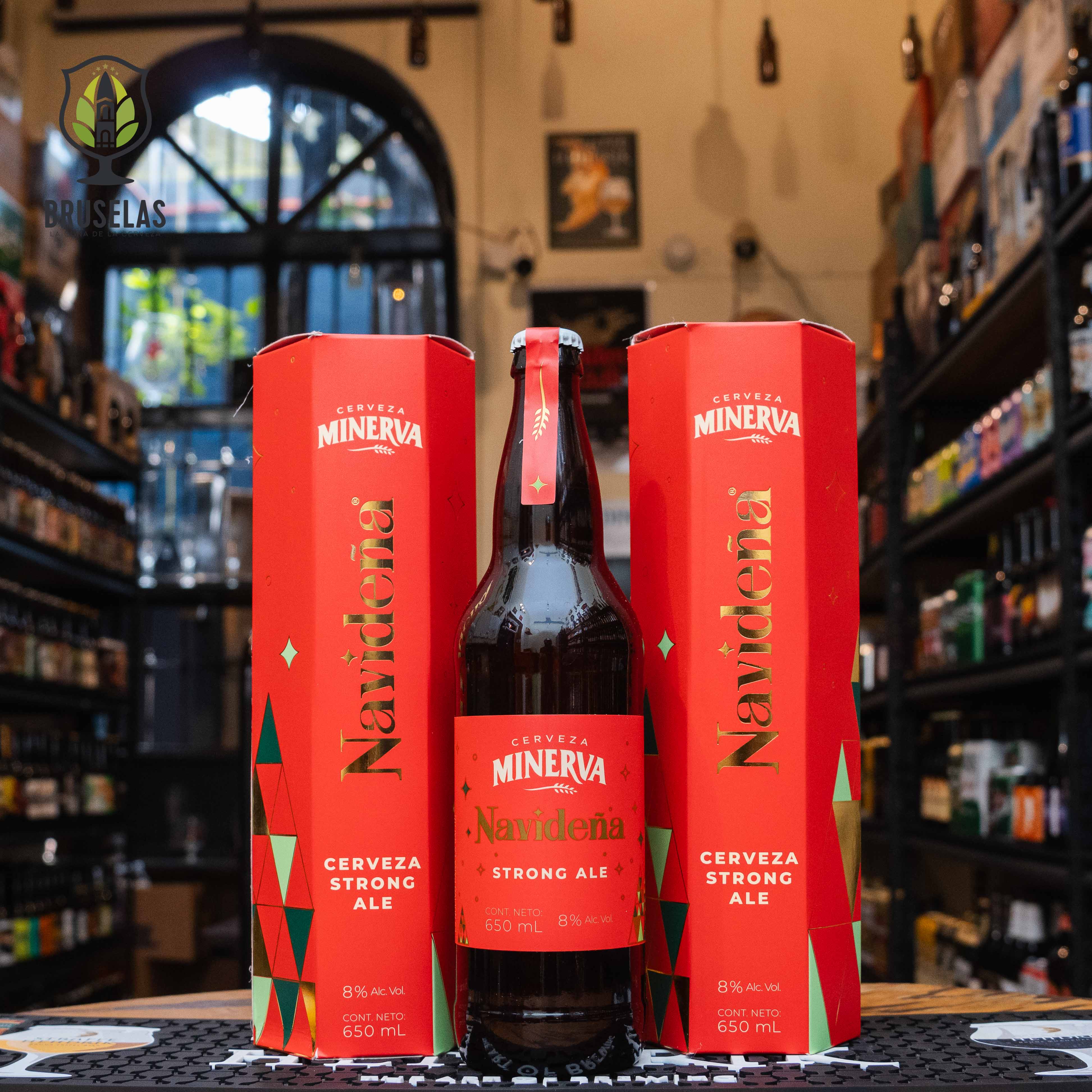 Botella deMinerva Navideña Strong Ale, una edición especial de Cervecería Minerva de México. Presentada en caja y etiqueta roja con detalles dorados y verdes, con un ABV de 8%. Esta strong ale ofrece aromas de naranja, mandarina y un toque de tejocote, ideal para celebrar en Navidad. Sabor equilibrado entre dulzor y amargor, perfecta para acompañar costillas, panettone y pato asado. Diseño festivo que evoca la temporada navideña.