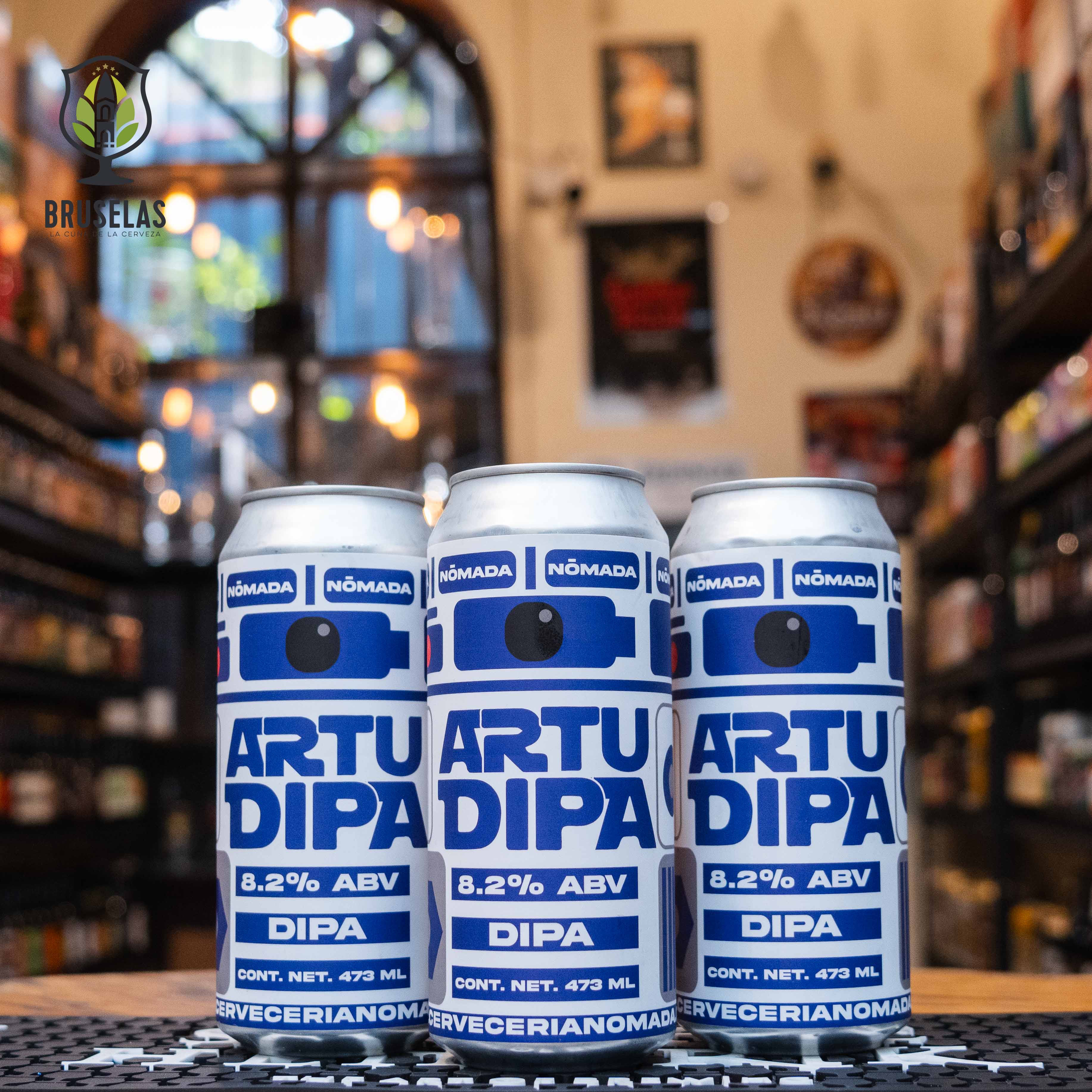 Lata de Artu DIPA de Nómada Brewing, una Double IPA con un ABV de 8.2%. La etiqueta, inspirada en el icónico personaje R2-D2 de Star Wars, es de color blanco y azul con un diseño minimalista que evoca el famoso droide. Con intensas notas cítricas de toronja y naranja, es ideal para maridar con carnes a la parrilla y quesos fuertes. El diseño refleja una fusión de cultura pop y creatividad cervecera.