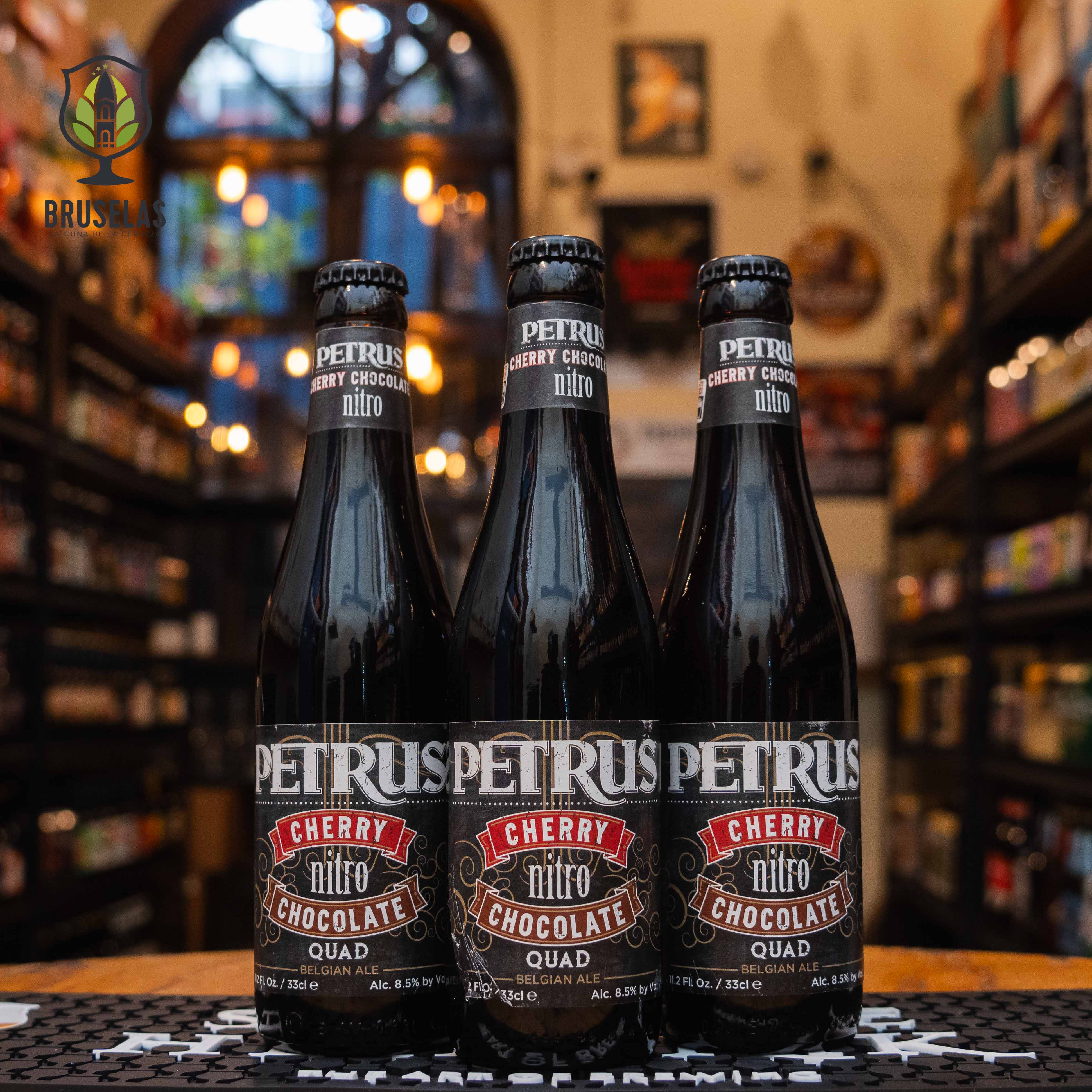 Botella de Petrus Cherry Chocolate Nitro, una cerveza belga estilo Quad elaborada por Brouwerij De Brabandere, Bélgica. La etiqueta tiene un diseño oscuro con letras blancas y detalles rojos, destacando los sabores de cereza y chocolate. Presenta un ABV de 8.5%, con un perfil de sabor que combina el dulzor del chocolate con la acidez de la cereza, complementado por una textura cremosa gracias al nitrógeno. Ideal para acompañar postres de chocolate y tartas de cereza.