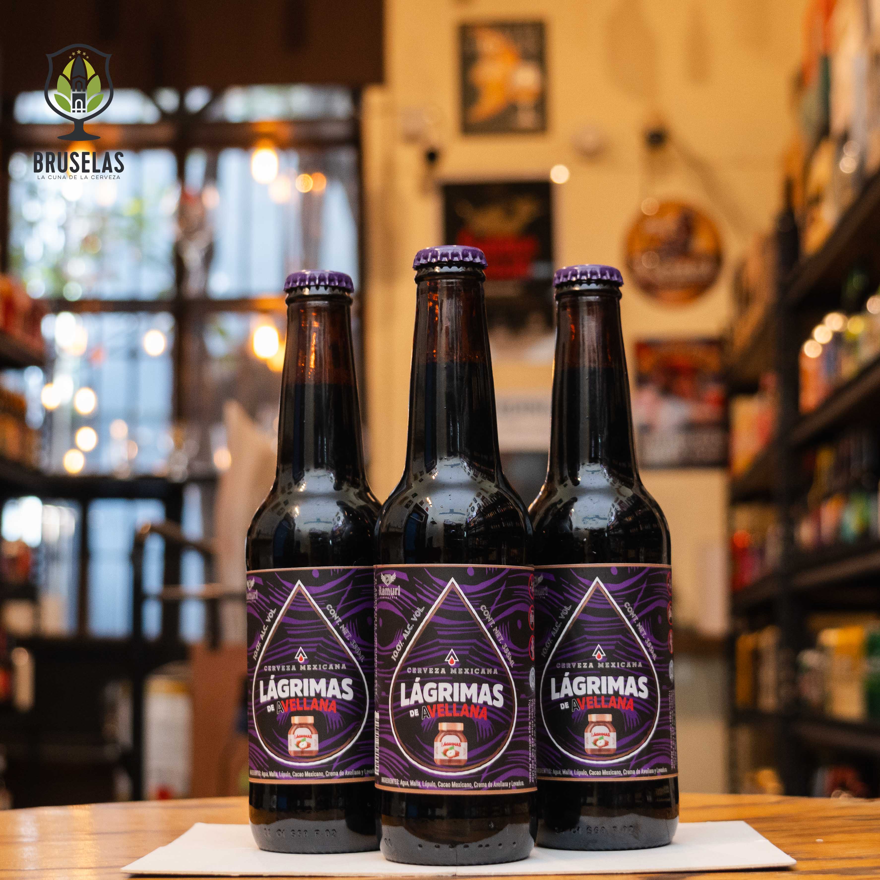 Botella de Rámuri Lágrimas de Avellana, una Russian Imperial Stout de Cervecería Rámuri con un ABV de 10% y 34 IBU. Ofrece aromas de chocolate, malta tostada y avellana. Su sabor es profundo, con notas de chocolate oscuro, vainilla y avellana, y un final cálido y dulce. Ideal para maridar con postres de chocolate, quesos fuertes y carnes asadas. Refleja intensidad y complejidad.