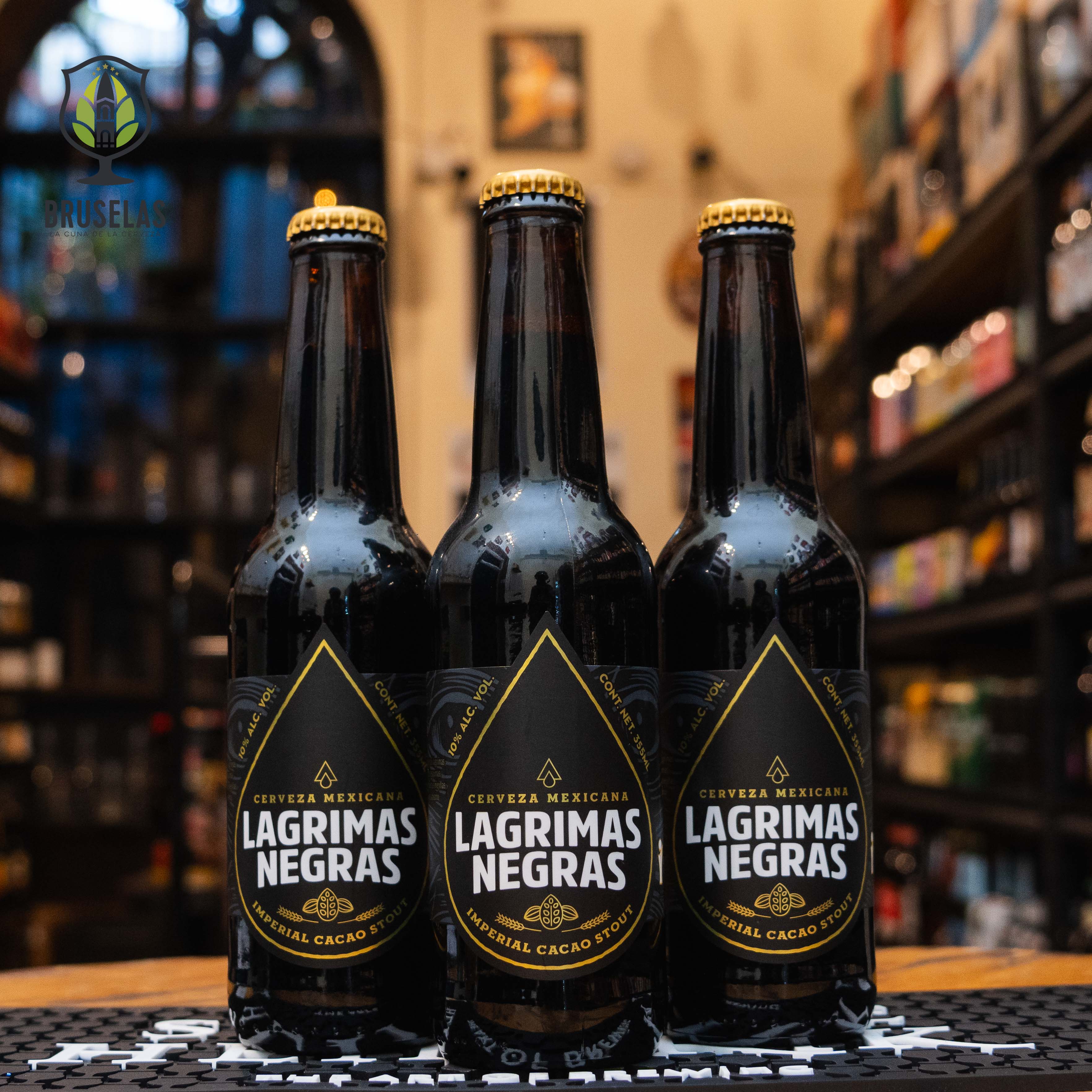 Botella de Lágrimas Negras, una cerveza artesanal estilo Imperial Cacao Stout elaborada por Cervecería Rámuri en Tijuana, Baja California, México. La etiqueta es oscura con detalles dorados y el nombre "Lágrimas Negras" en letras blancas prominentes. Con un ABV de 10%, ofrece aromas a malta tostada, chocolate y café, acompañados de un sabor equilibrado que combina chocolate, avena y un toque amargo suave. Ideal para acompañar postres de chocolate, carnes asadas y quesos fuertes.