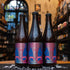 Botella de The Real Kinky Breakfast, una Sour Ale de Santa Sabina Brewery. La etiqueta tiene un diseño colorido con manos esposadas y tonos rosados y azules. ABV de 5.5%, con aromas de frambuesa fresca y café oaxaqueño. Sabor ácido y refrescante con un equilibrio entre frambuesa y café. Ideal para acompañar postres de frutas, quesos frescos y platos con ingredientes ácidos.