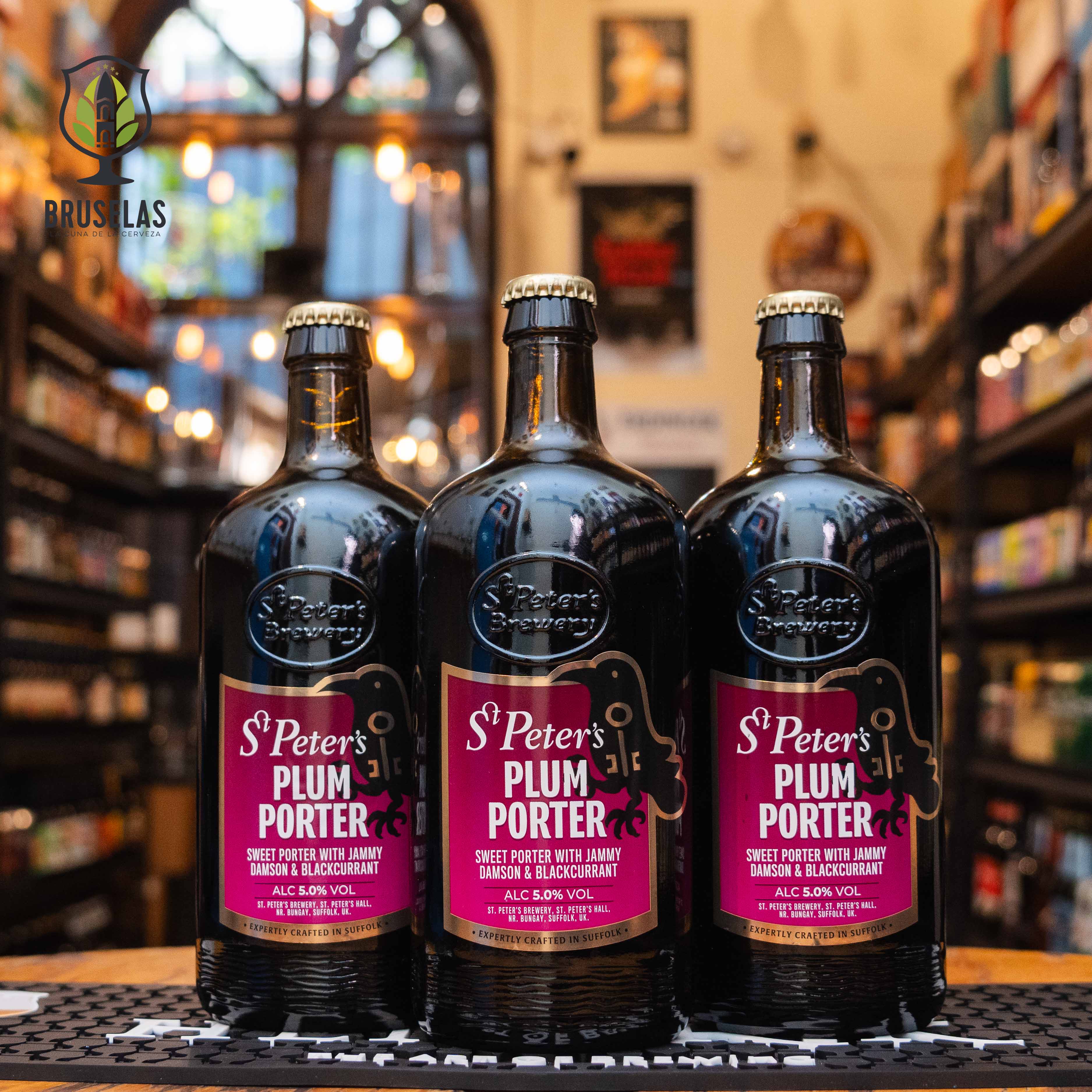 Botella de St. Peter's Plum Porter, una cerveza estilo porter de St. Peter's Brewery con un ABV de 5.0%. La etiqueta es de color púrpura con detalles en negro y dorado. Esta porter destaca por sus aromas de ciruelas y grosella negra, con un sabor dulce y afrutado equilibrado por notas maltosas. Ideal para maridar con postres de frutas y quesos maduros o disfrutar sola como sobremesa.