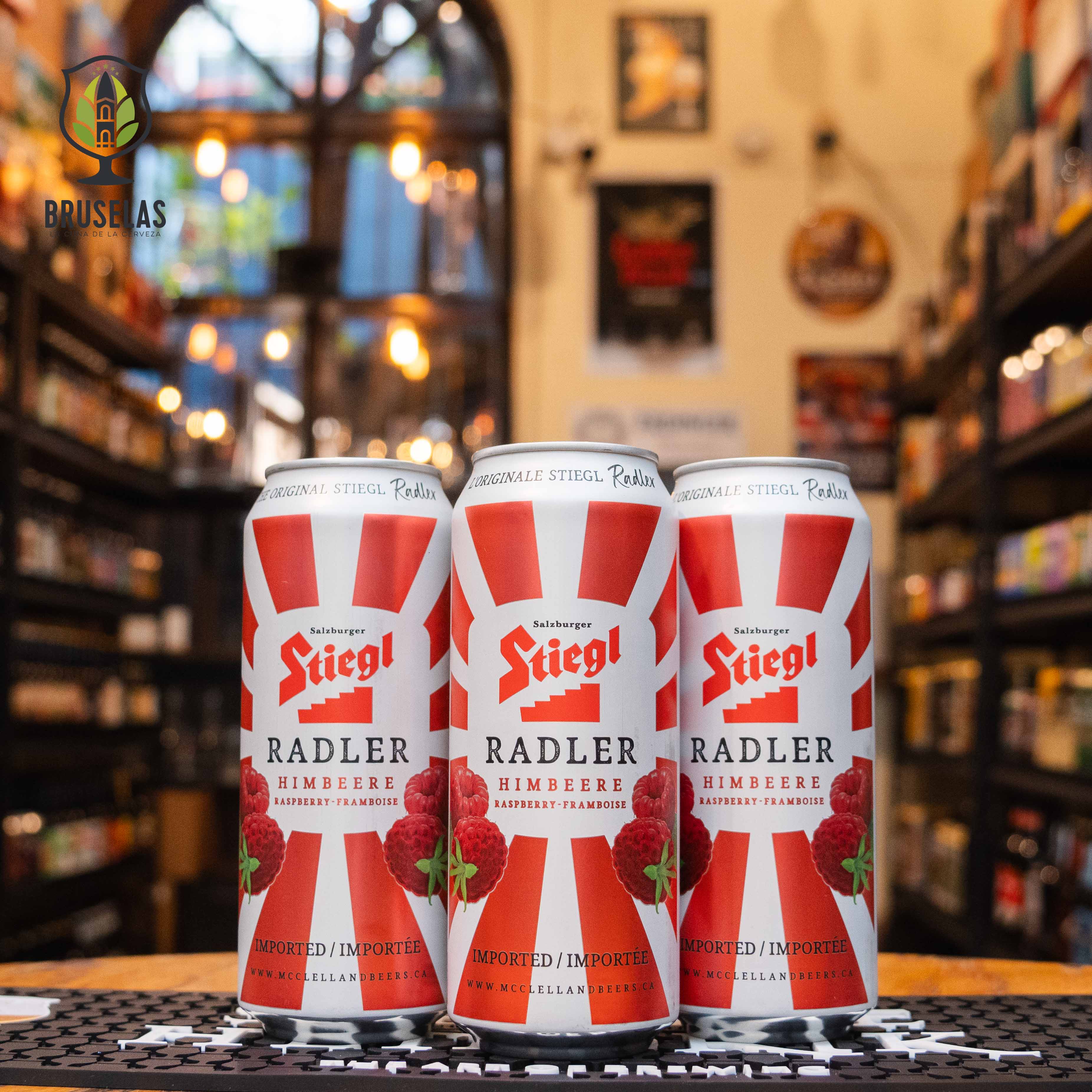 Stiegl Radler Himbeere, una mezcla de cerveza y soda de frambuesa, elaborada por Stiegl en Austria. La lata tiene un diseño rojo y blanco con imágenes de frambuesas. Con un 2% de alcohol, su sabor es dulce y afrutado, con un toque de acidez. Ideal para acompañar postres ligeros como sorbetes o disfrutar en un día soleado. El diseño refleja frescura y vibrancia.