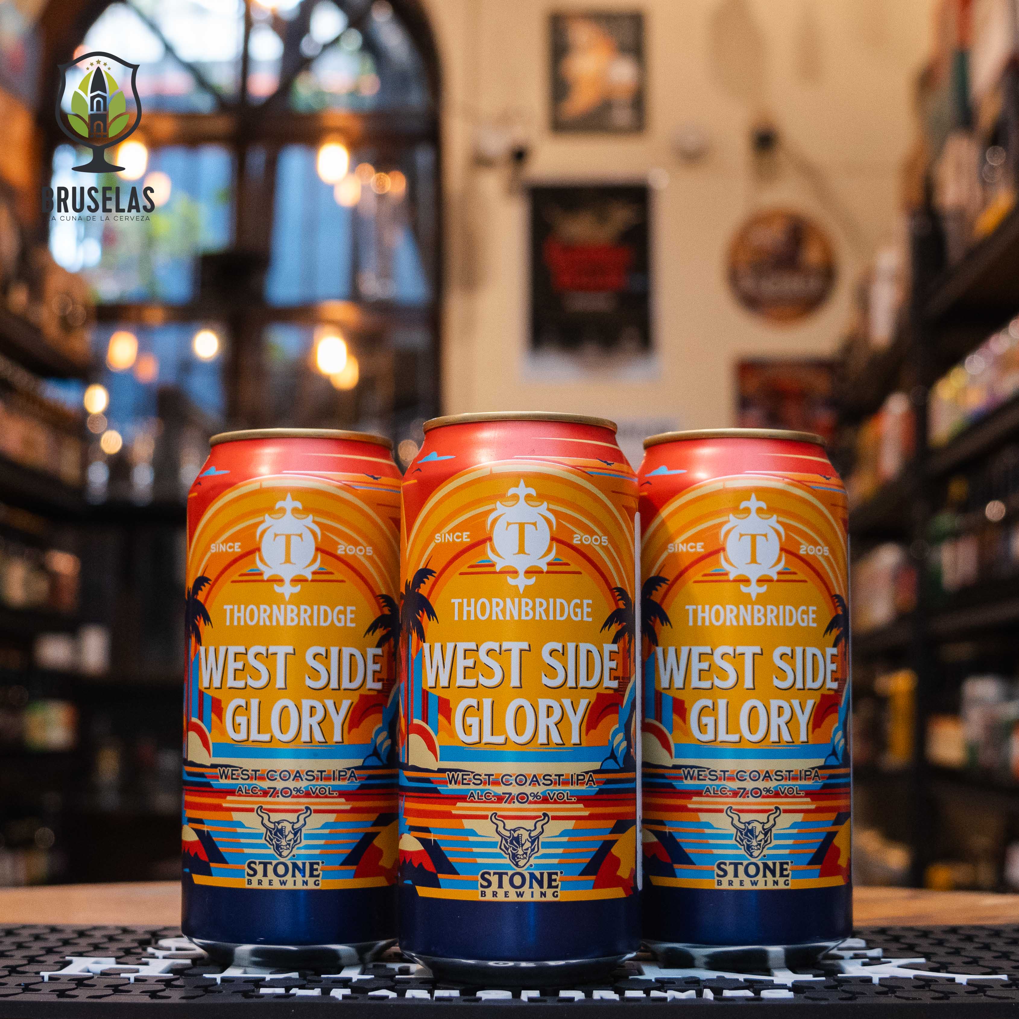 Lata de Thornbridge West Side Glory, una West Coast IPA de Thornbridge Brewery y Stone Brewing. La etiqueta tiene un diseño en tonos naranja y amarillo con palmeras y un atardecer. El nombre aparece en letras blancas grandes. Con un ABV de 7.0%, ofrece notas de pino, toronja y mandarina. Ideal para acompañar tacos de pescado. Diseño vibrante que refleja el estilo californiano.