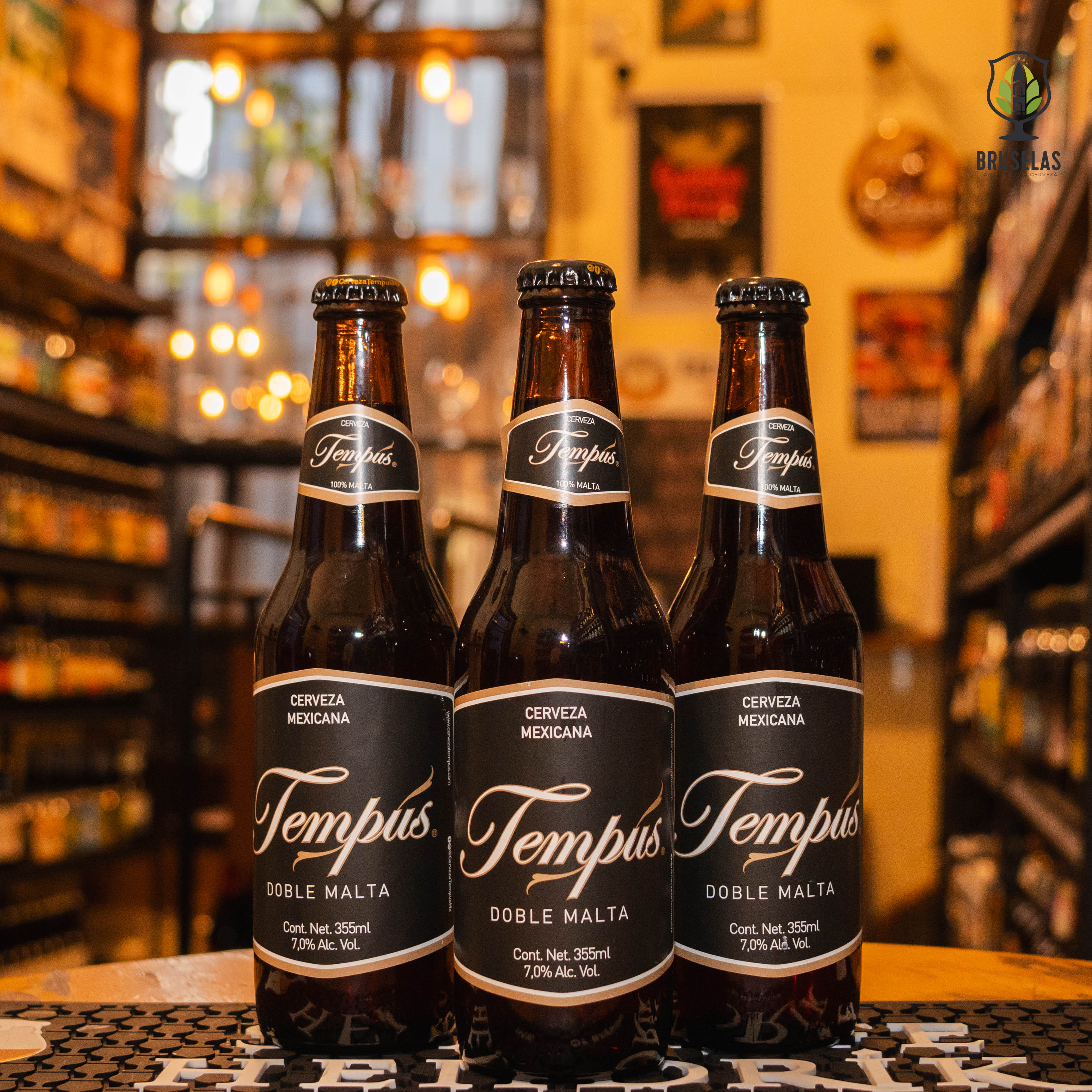 Botella de Tempus Doble Malta, una Imperial Altbier mexicana con un ABV de 7%. Presenta aromas y sabores intensos de malta tostada, caramelo y un toque de vainilla. De color ámbar oscuro y espuma densa, esta cerveza ofrece un equilibrio entre dulzura y amargor, con un final suave y persistente. Ideal para maridar con carnes a la parrilla, quesos añejos y postres de chocolate. Presentación en botella de 355 ml.