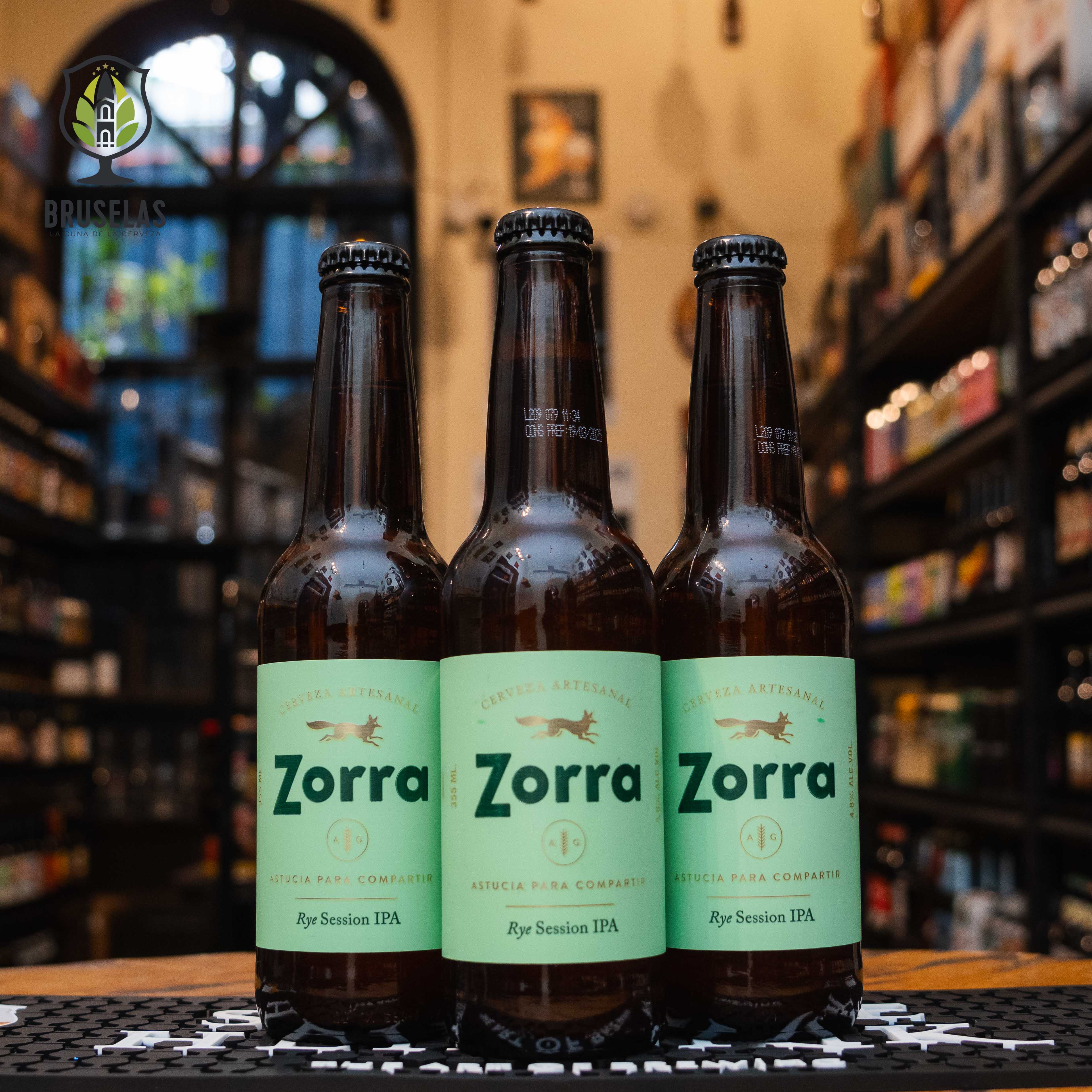 Botella de Zorra Rye Session IPA, una cerveza artesanal con un ABV de 4.8% y 45 IBU. La etiqueta es verde claro con detalles minimalistas. Sabor fresco con notas de cáscara de naranja, frutas tropicales y un toque especiado de centeno. Ideal para acompañar tacos al pastor, hamburguesas y quesos curados. El diseño refleja la ligereza y frescura de esta cerveza.