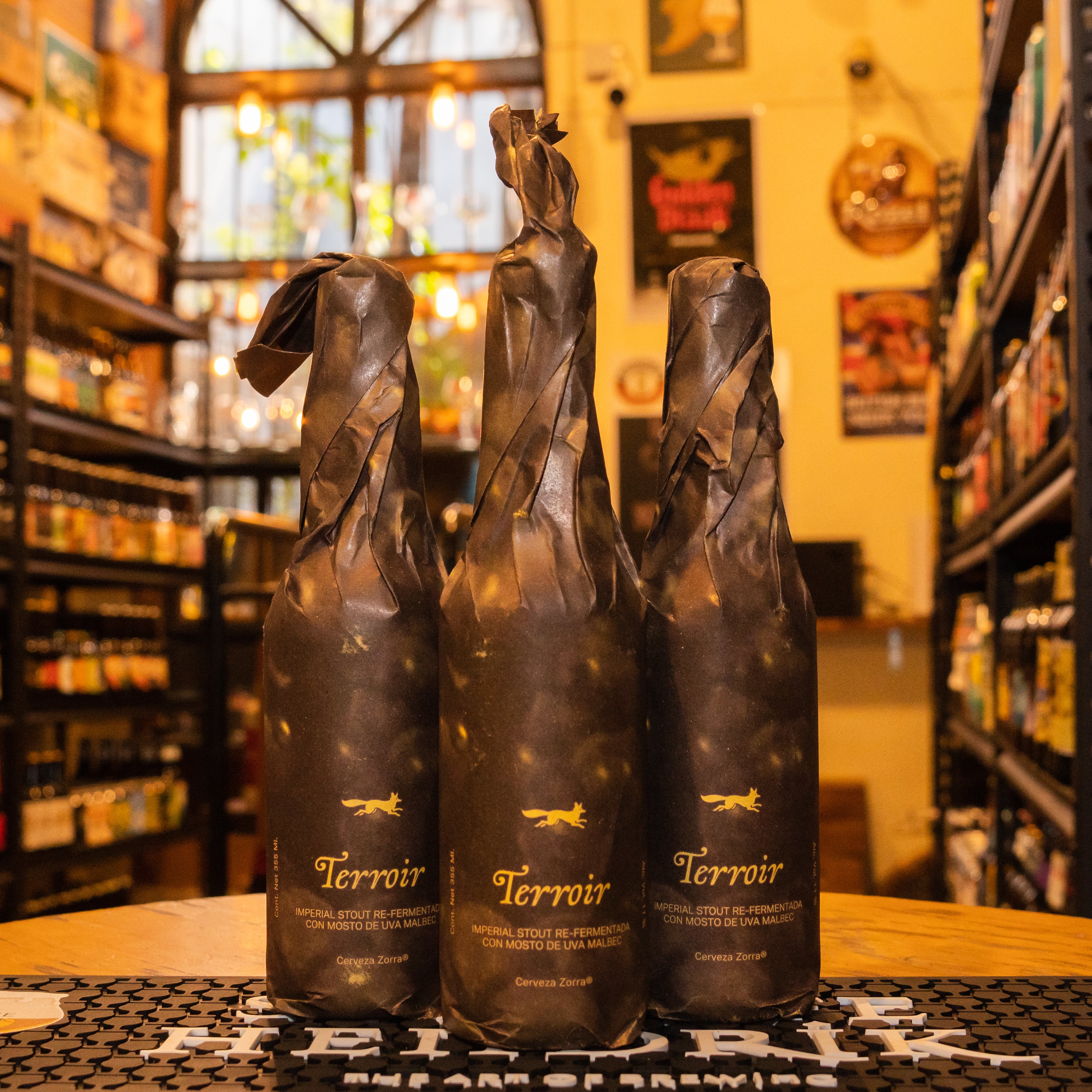 Botella de Zorra Terroir, una Imperial Stout de Cervecería Zorra con ABV de 11%. Doble fermentación con mosto de uva Malbec de Aguascalientes. Aromas a chocolate amargo, café y notas de vino. Sabor a cacao, café tostado y un toque de vino que aporta profundidad. Ideal para maridar con carnes asadas, postres de chocolate amargo y quesos curados. Refleja un estilo robusto y bien estructurado.