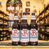 Botella de Bombardier Amber Beer, una Amber Ale de Eagle Brewery, elaborada en el Reino Unido. La etiqueta presenta un diseño clásico en tonos rojos y dorados, destacando su carácter británico. Con un ABV de 4.7%, ofrece aromas de cítricos, especias y galletas, con un sabor suave de caramelo y un final ligeramente seco. Ideal para acompañar carnes rojas, estofados y postres de chocolate. Su diseño refleja la tradición cervecera inglesa.