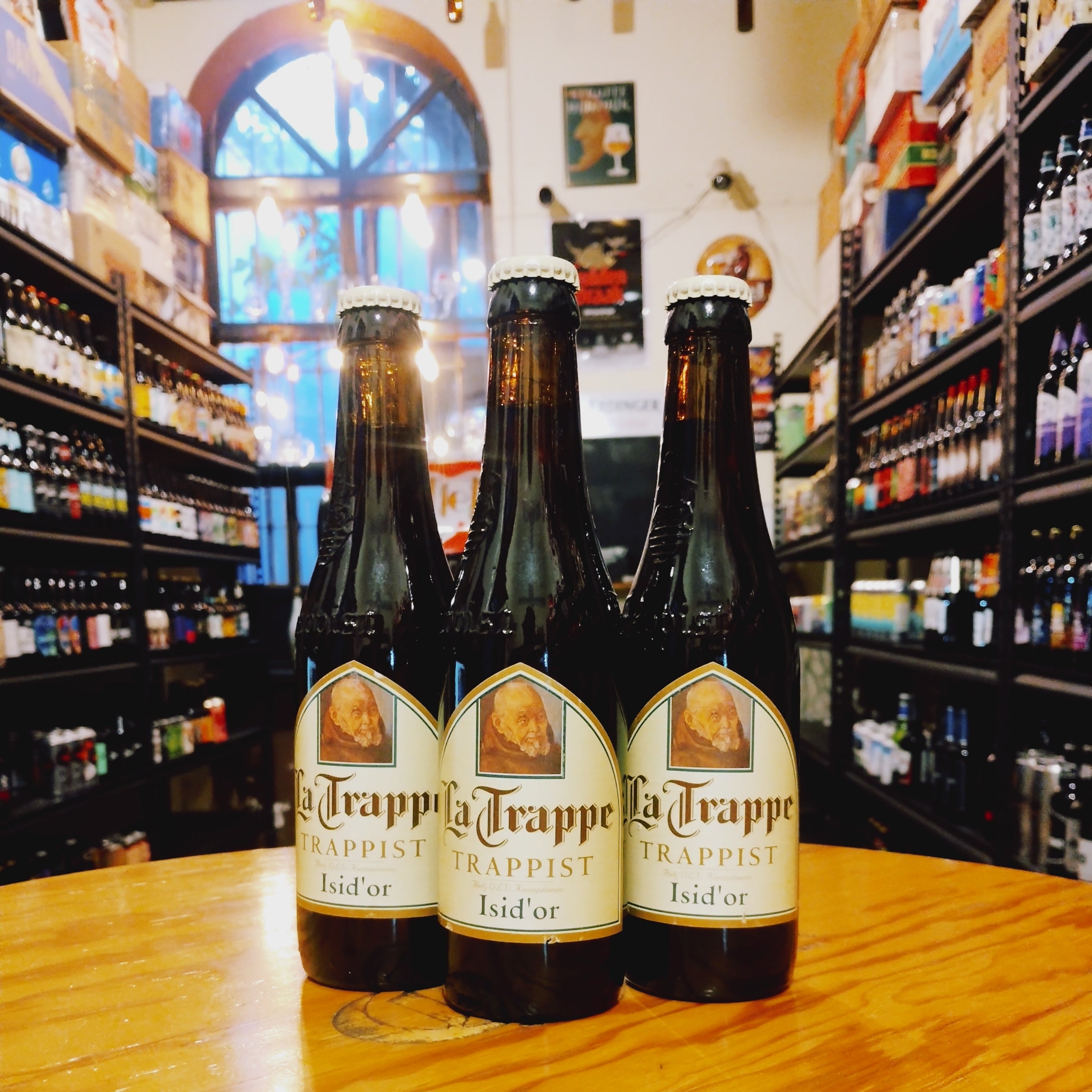 Botella de La Trappe Isid'or, una Belgian Pale Ale de la cervecería trapense Koningshoeven. Con un ABV de 7.5%, presenta un color ámbar profundo y espuma cremosa. Ofrece aromas frutales, especiados y de caramelo. Su sabor combina dulzura maltosa con toques de frutas y especias, equilibrado por un suave amargor. Ideal para maridar con platos de caza, quesos maduros y postres con frutos secos o caramelo.