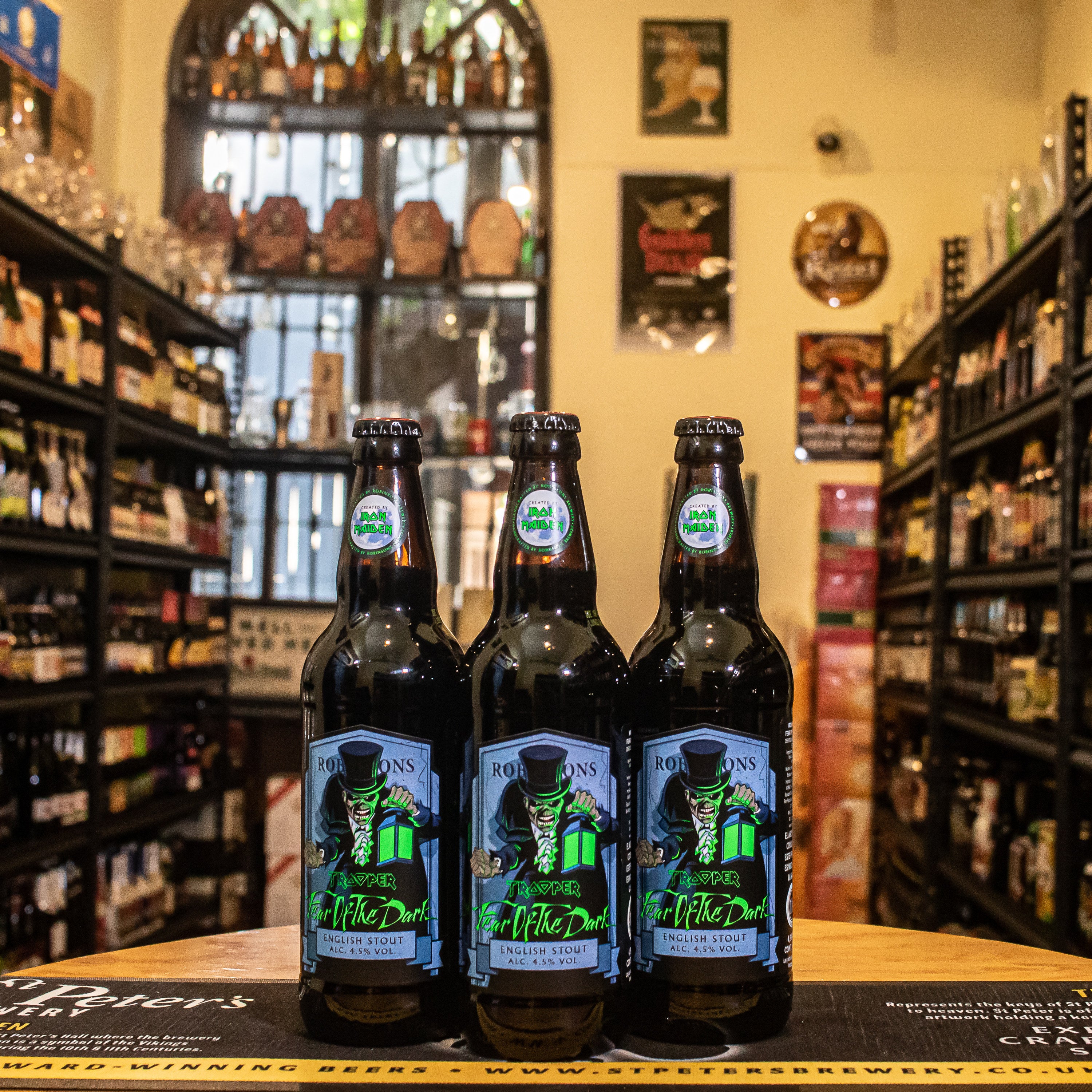 Botella de Iron Maiden: Fear of the Dark, una English Stout elaborada por Robinsons Brewery en colaboración con la banda Iron Maiden. Con un ABV de 4.5%, ofrece aromas de chocolate tostado y maltas oscuras. Su sabor es intenso y equilibrado, con predominancia de chocolate. Ideal para acompañar postres de chocolate y quesos fuertes. Inspirada en la icónica canción y álbum "Fear of the Dark